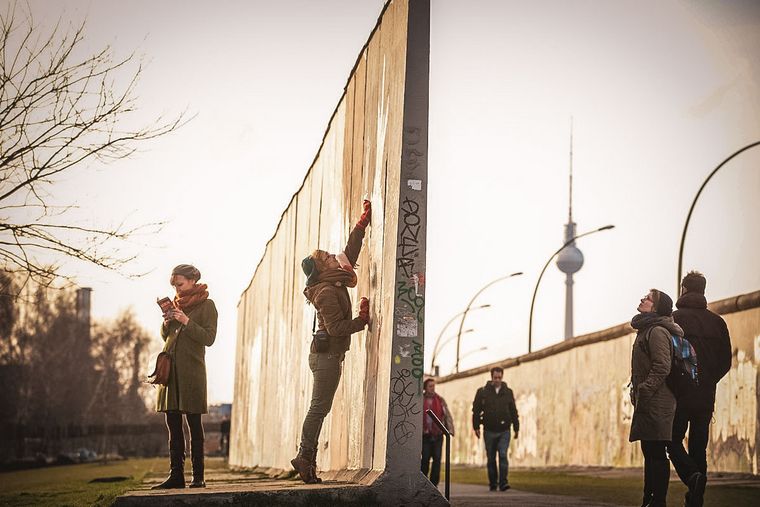 Schülerinnen an der Berliner Mauer: Für Klassenfahrten nach Berlin gibt es Finanzierungshilfen.