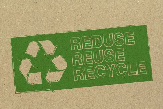 Ein Stück braunes Recyclingpapier mit grüner Aufschrift "Reduse, reuse, recycle"