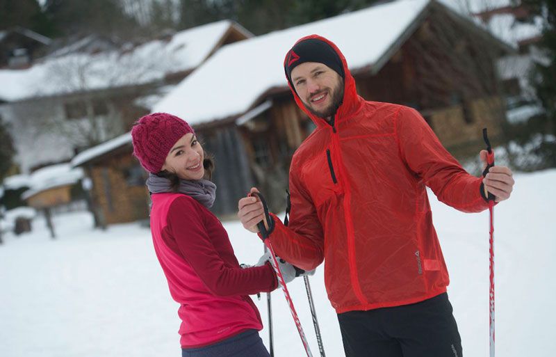 Mann und Frau mit Skiern beim Wintersport in der Jugendherberge
