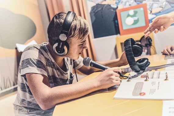 Ein Junge sitzt in einem Tonstudio in Bad Hersfeld und produziert dort eine Kindernachrichtensendung. 