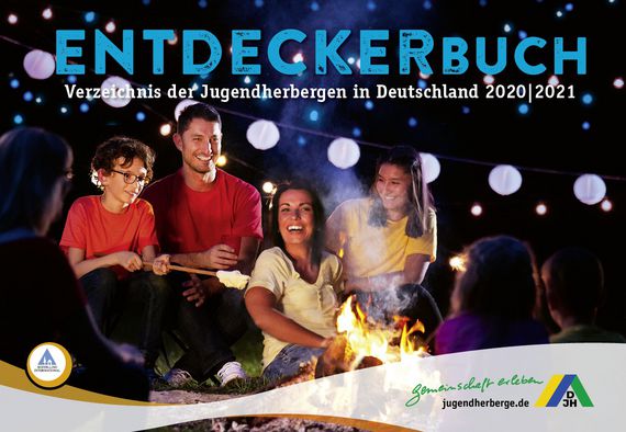 Eine fröhliche Familie am Lagerfeuer, darüber der Schriftzug "Entdeckerbuch - Verzeichnis der Jugendherbergen in Deutschland 2020/2021"