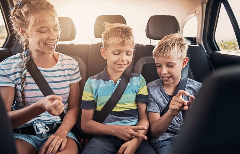 Drei Kinder sitzen in einem Auto