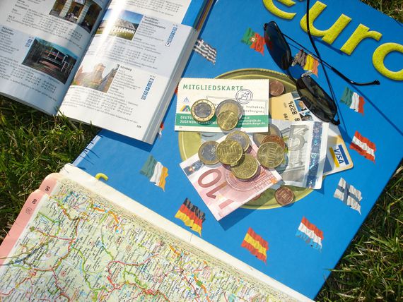 Auf einer Landkarte liegen Geldscheine und Münzen