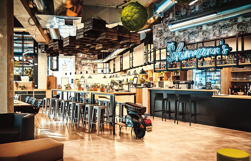 Ein modernes Restaurant mit einer Bar und dem leuchtenden Schriftzug Schirrmann´s