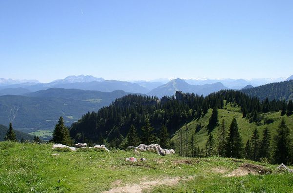Blick über grüne Wiesen, Wälder und Berge bei der Kampenwand in den Chiemgauer Alpen. 