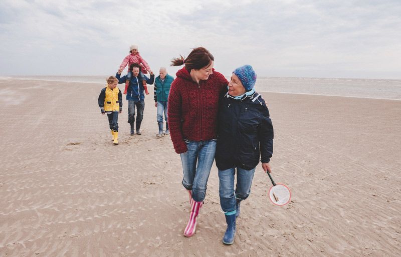 Eine Familie spaziert am Strand entlang