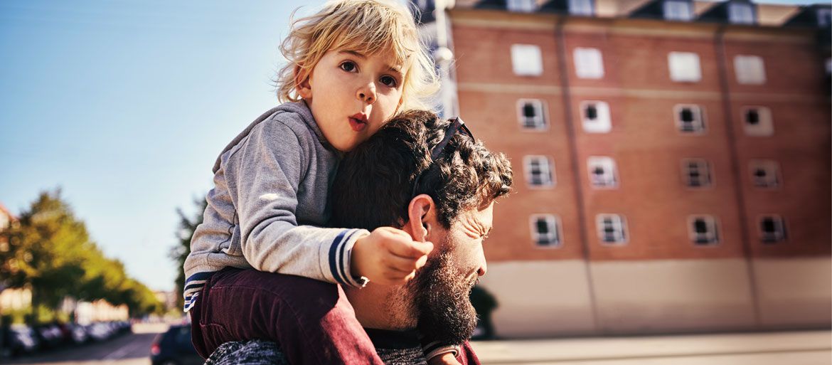 Kind auf den Schultern von Papa in einer Kleinstadt in Deutschland
