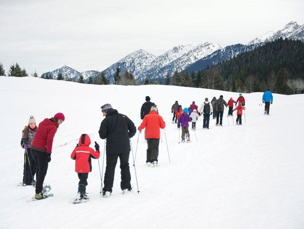 Skischule mit vielen Kindern und Betreuern im tiefen Schnee im Winterurlaub