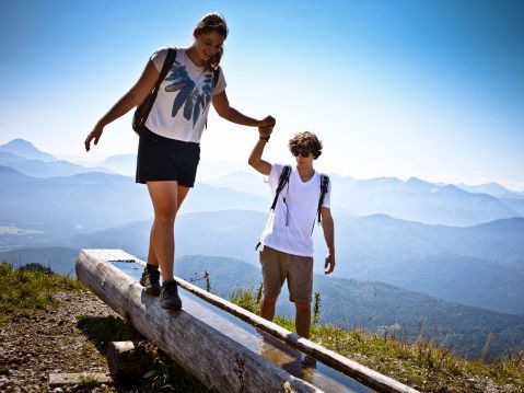 2 Jugendliche wandern mit tollem Blick auf die bayerischen Alpen