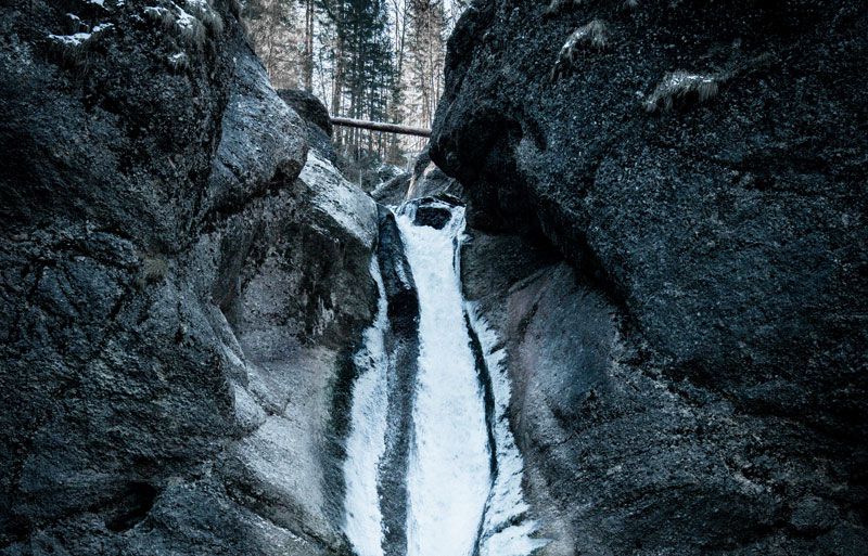 Wintersport in Oberstaufen: Besuch bei einem Wasserfall im Gebirge