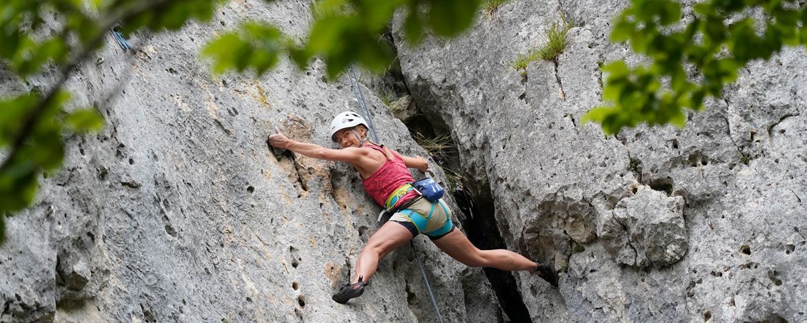 Eine Frau klettert an einer Felswand 