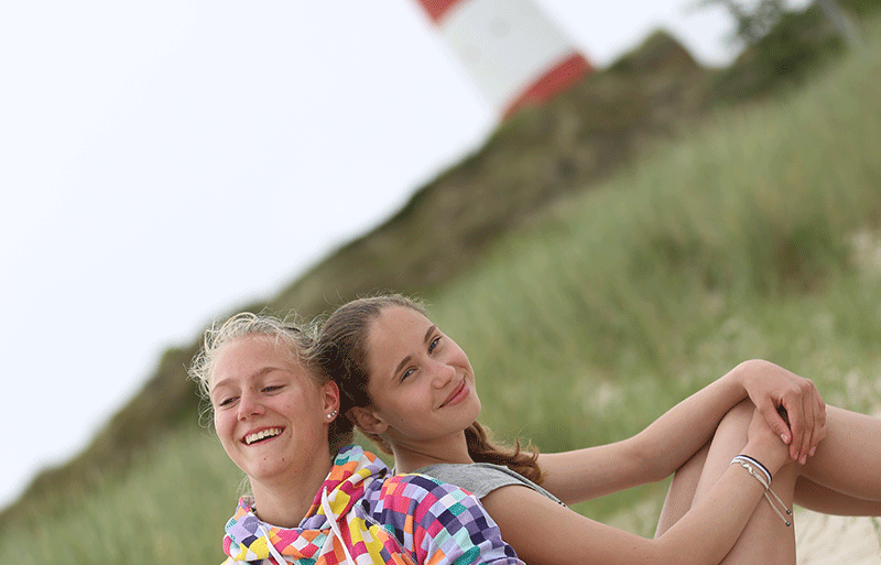 Zwei Mädchen am Strand vor dem Leuchtturm auf Sylt