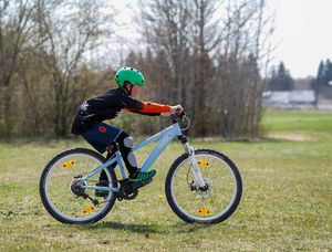 Ein Kind übt die Gewichtsverlagerung nach hinten auf dem Mountainbike