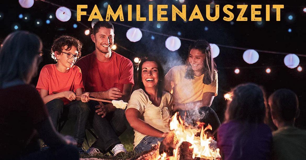 Eine lachende Familie sitzt am warmen Lagerfeuer. Der Mann auf der rechten Seite trinkt einen Tee, während sein Sohn neben ihm Stockbrot ins Feuer hält. Oben steht der Begriff Familienauszeit.