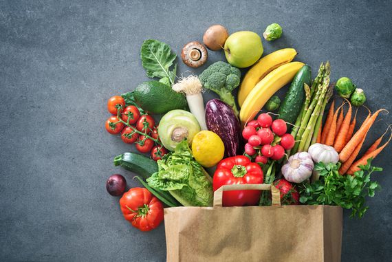 Das Bild zeigt eine Papiereinkaufstüte, die mit vielen Sorten Gemüse und Obst gefüllt ist