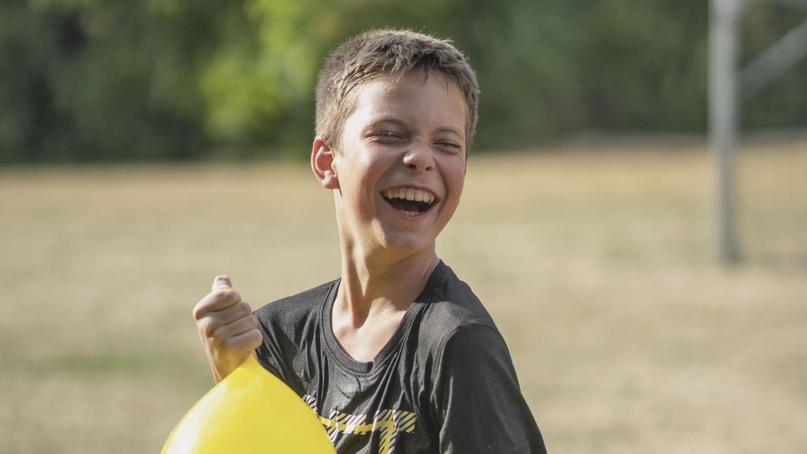 Lachender Junge hält einen Luftballon