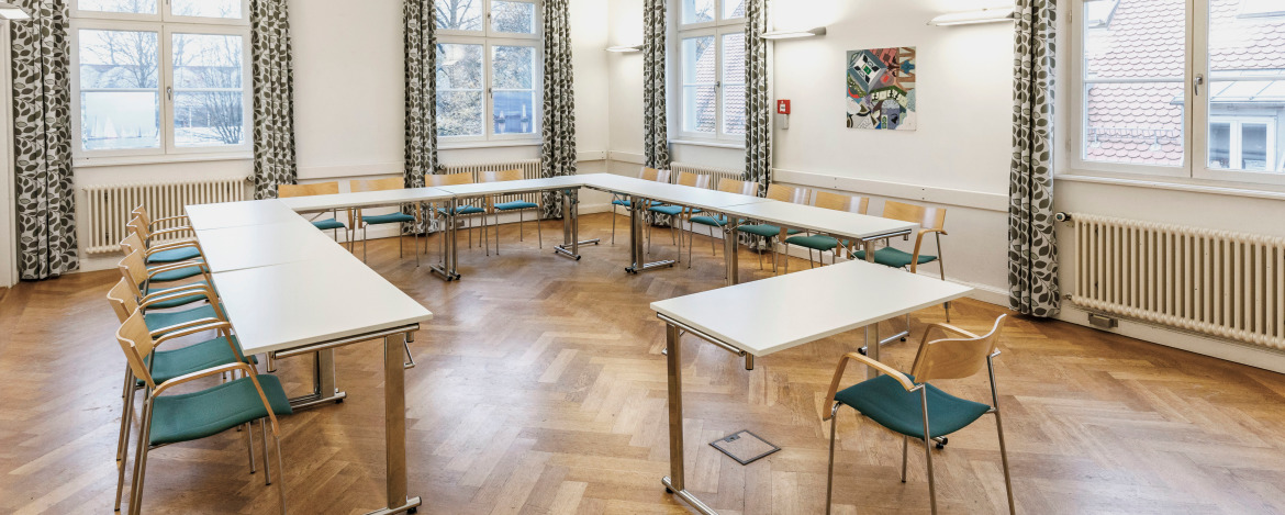 Der Raum Lindau in der Jugendherberge Lindau ist ausgestattet mit Tischen und Stühlen, viel Helligkeit und kann ideal zum Proben genutzt werden.