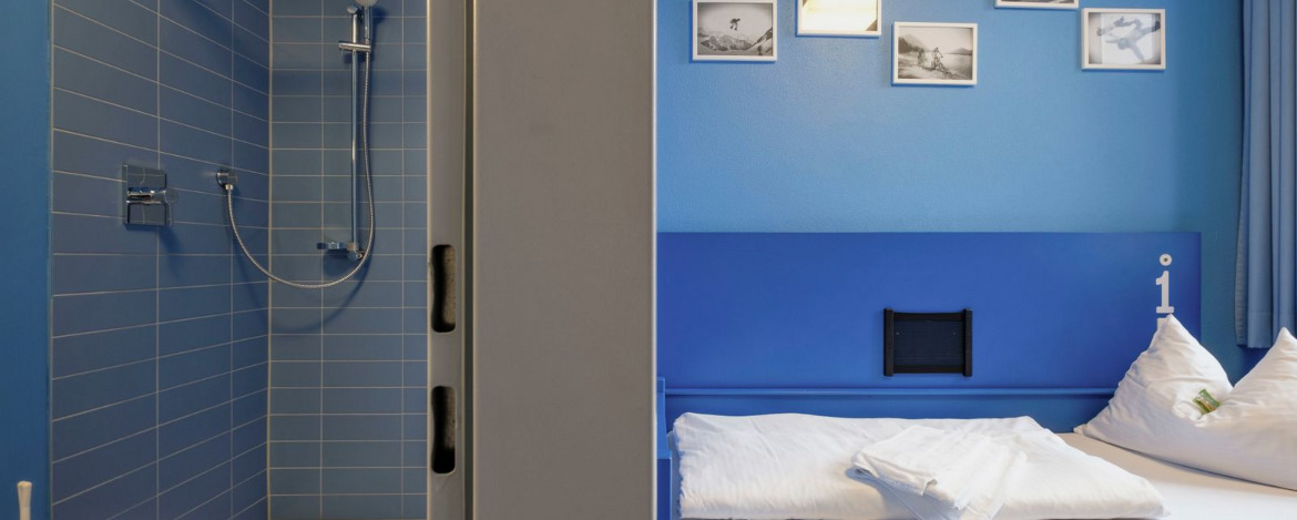 Zimmerbeispiel Einzelzimmer (blaue Variante) mit eigener Dusche/WC im Zimmer in der Jugendherberge Oberammergau.