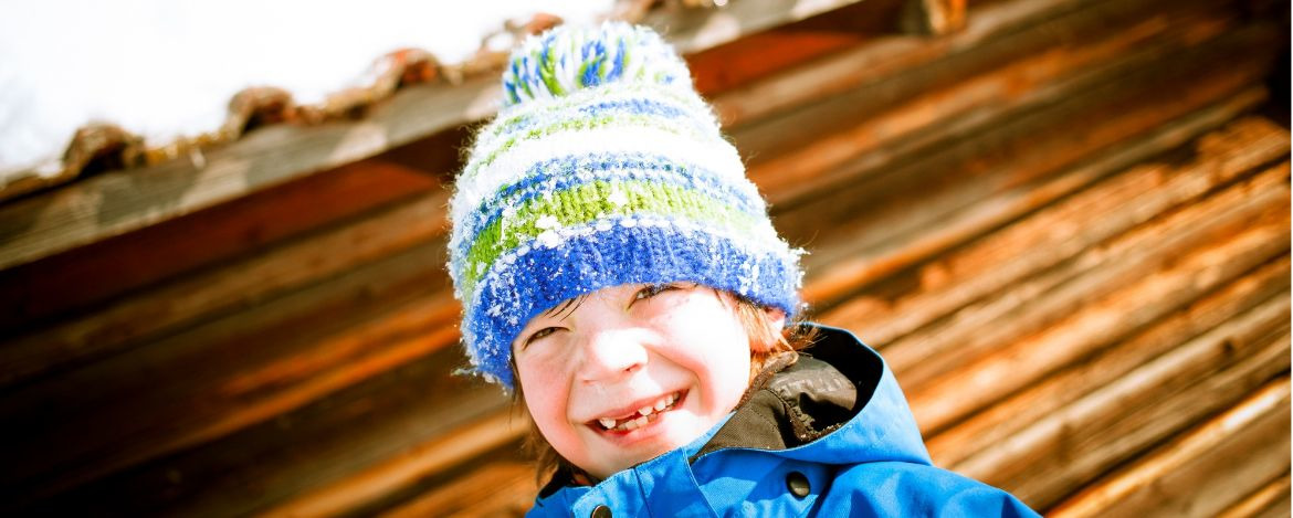 fröhliches Kind vor der Jugendherberge Mittenwald im Winter