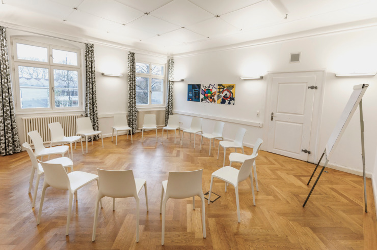 Der Seminarraum Bregenz in der Jugendherberge Lindau ist ausgestattet mit Stühlen in Kreisform, einem Flipchart, Bilder an den Wänden und viel Helligkeit.