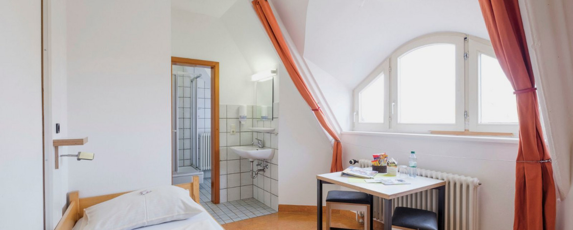 Zimmerbeispiel für ein Einbettzimmer mit Dusche/WC in der Jugendherberge Rothenburg ob der Tauber