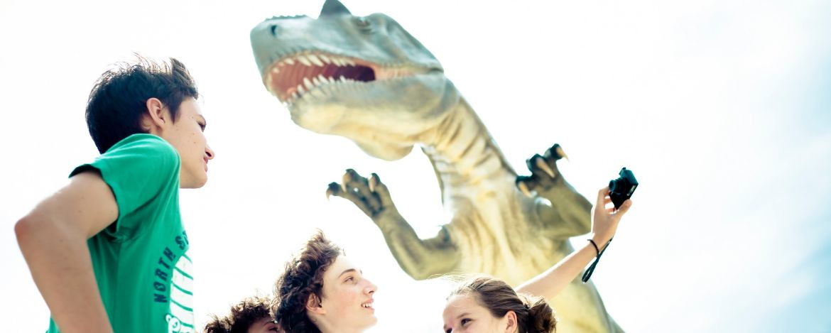 Schüler blicken fasziniert auf den lebensgroßen Tyrannosaurus Rex
